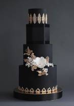 Торт черный с золотым оформлением с белыми цветами