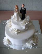 Торт с фигурками жениха и невесты украшен розами