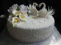 Торт с цветами и двумя лебедями с кольцами